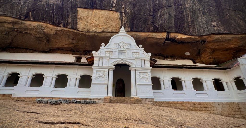 Front view of Dambulla Cave Temple in Sri Lanka, showing the rock face and temple entrance.